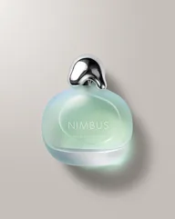 Frosted seafoam NIMBUS perfume bottle with a chrome cap on a pale gray backdrop